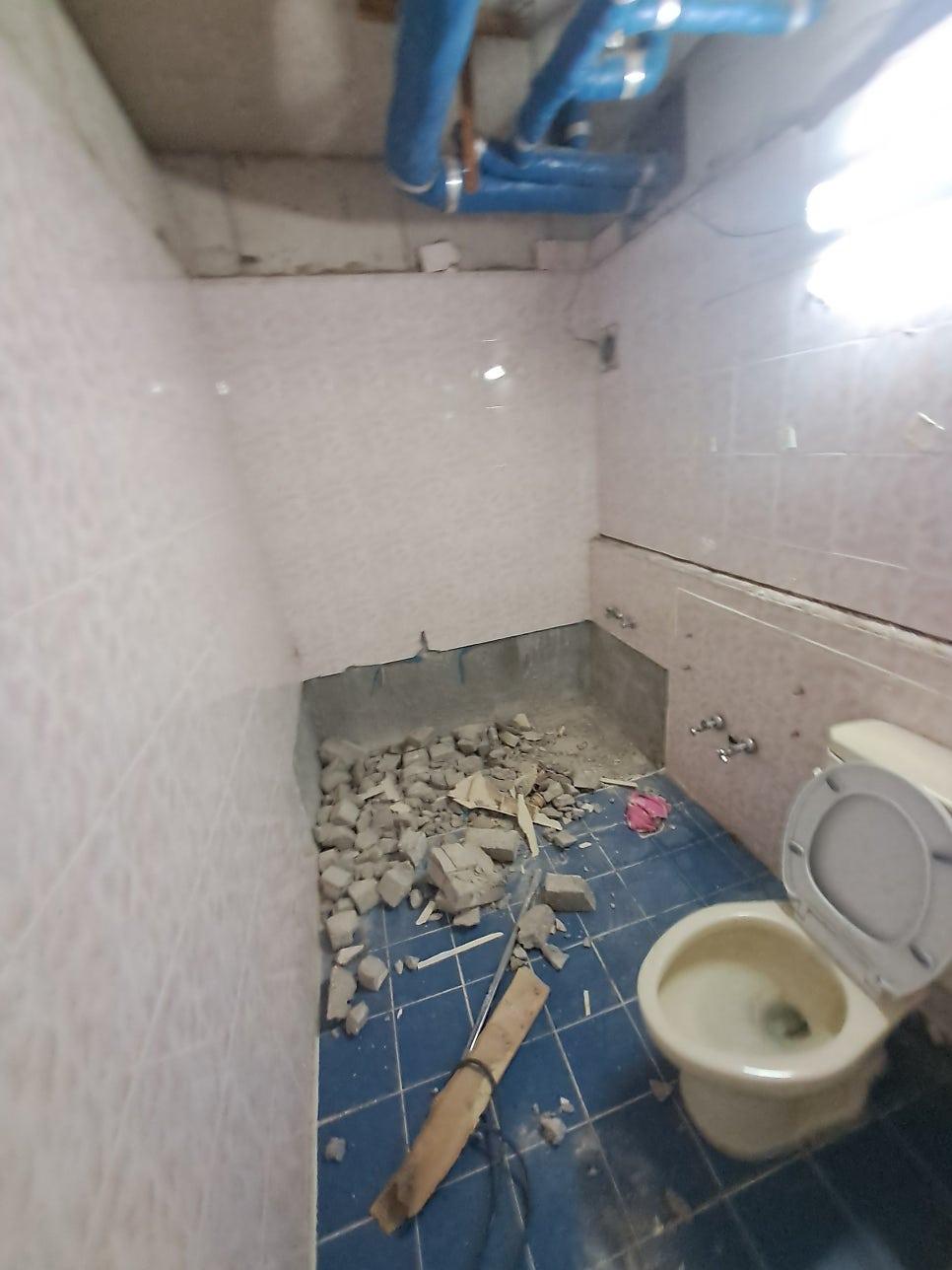 파란색 배관이 노출된 화장실 철거 현장