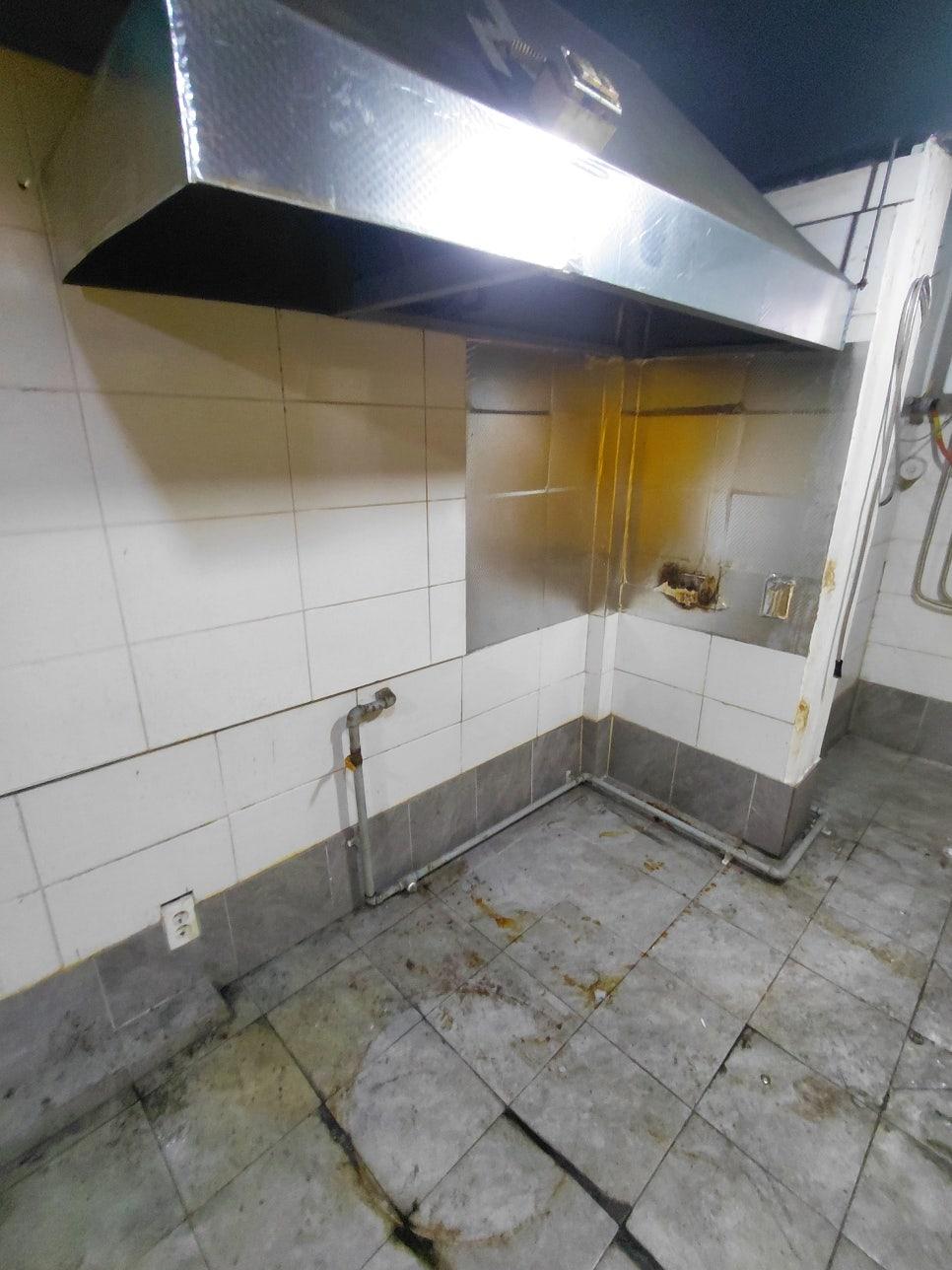 철제 레인지후드가 설치된 타일 주방