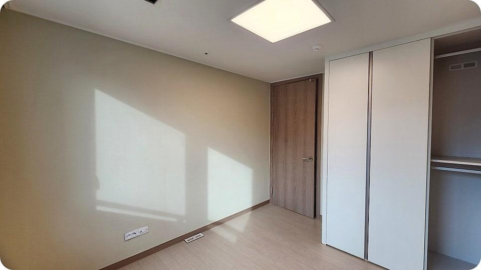수납장과 나무 문이 위치한 베이지색 벽면