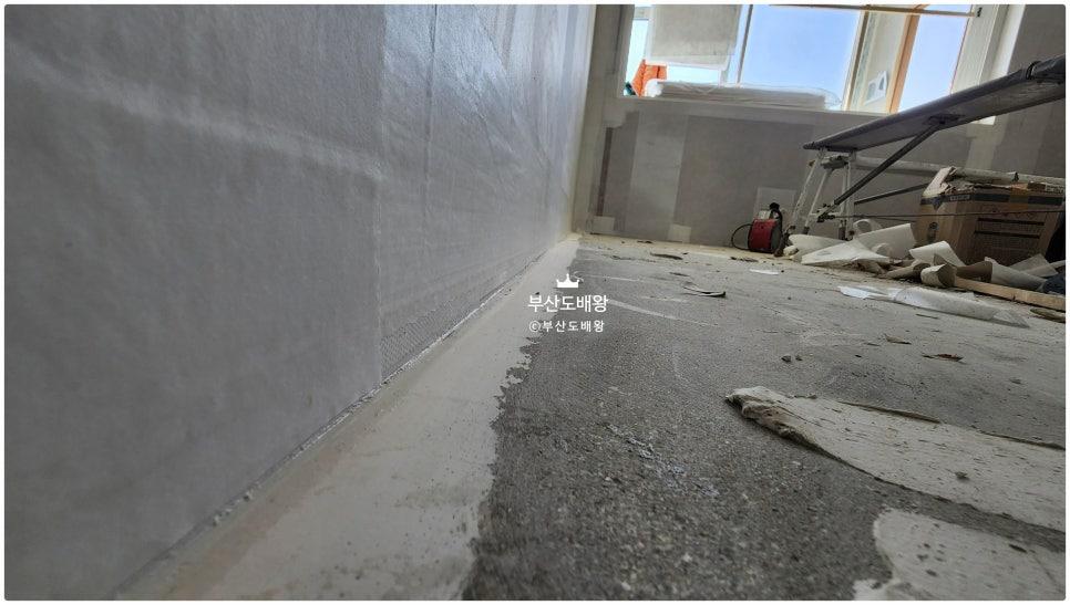 흰색 보호 필름이 덮인 벽면과 타일이 제거된 바닥