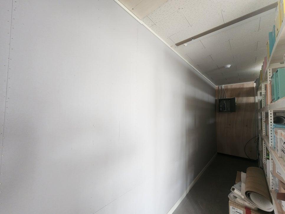 화이트 톤의 벽면과 우드톤 선반이 어우러진 완성된 실내