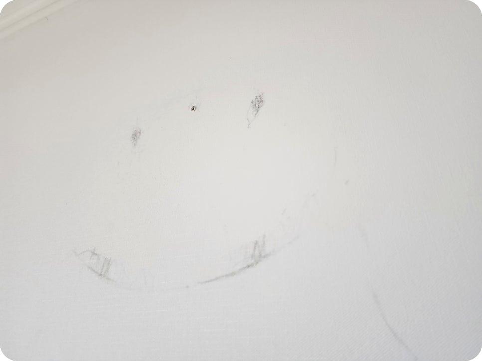 흰 벽면에 그려진 웃는 얼굴 그림