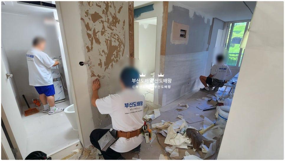 기존 벽지 철거 후 바닥에 자재 잔해가 놓인 시공 초기 모습