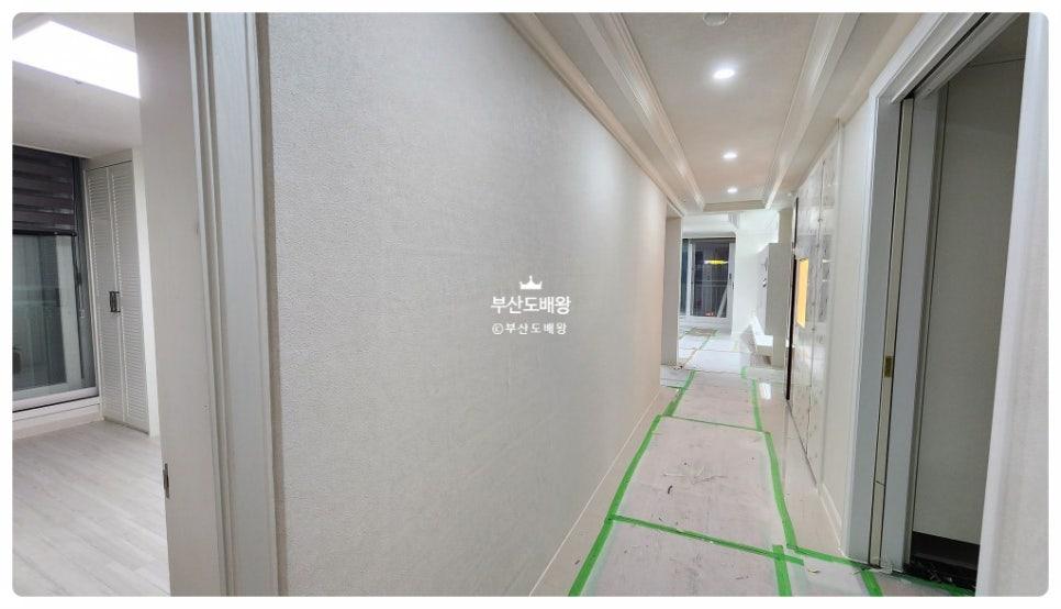 텍스처 벽면과 타일 바닥 마감이 진행 중인 복도