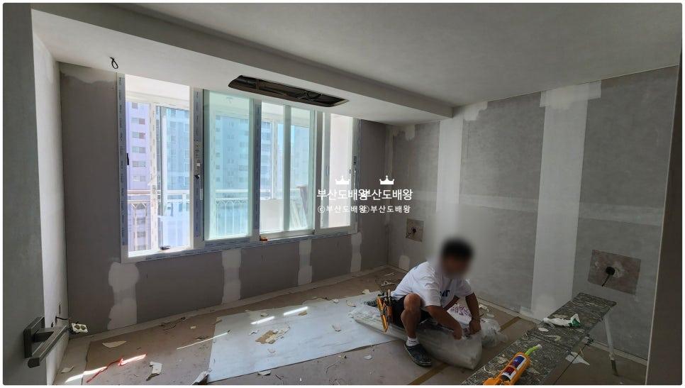 창가 벽면에 흰색 테이프로 보강 작업을 하는 과정