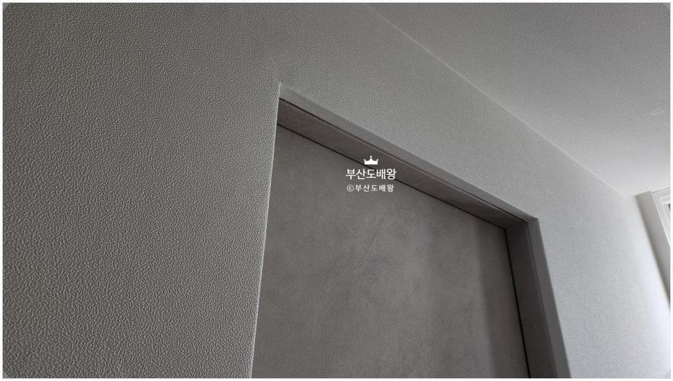 차분한 회색 톤으로 정돈된 벽과 도어 프레임