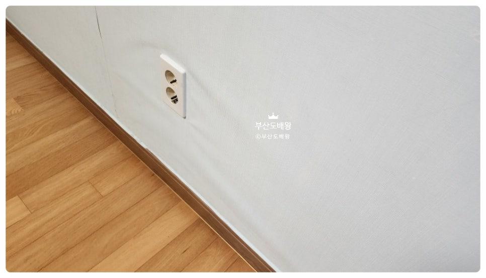 전선 소켓이 설치된 화이트 벽면과 마루 바닥