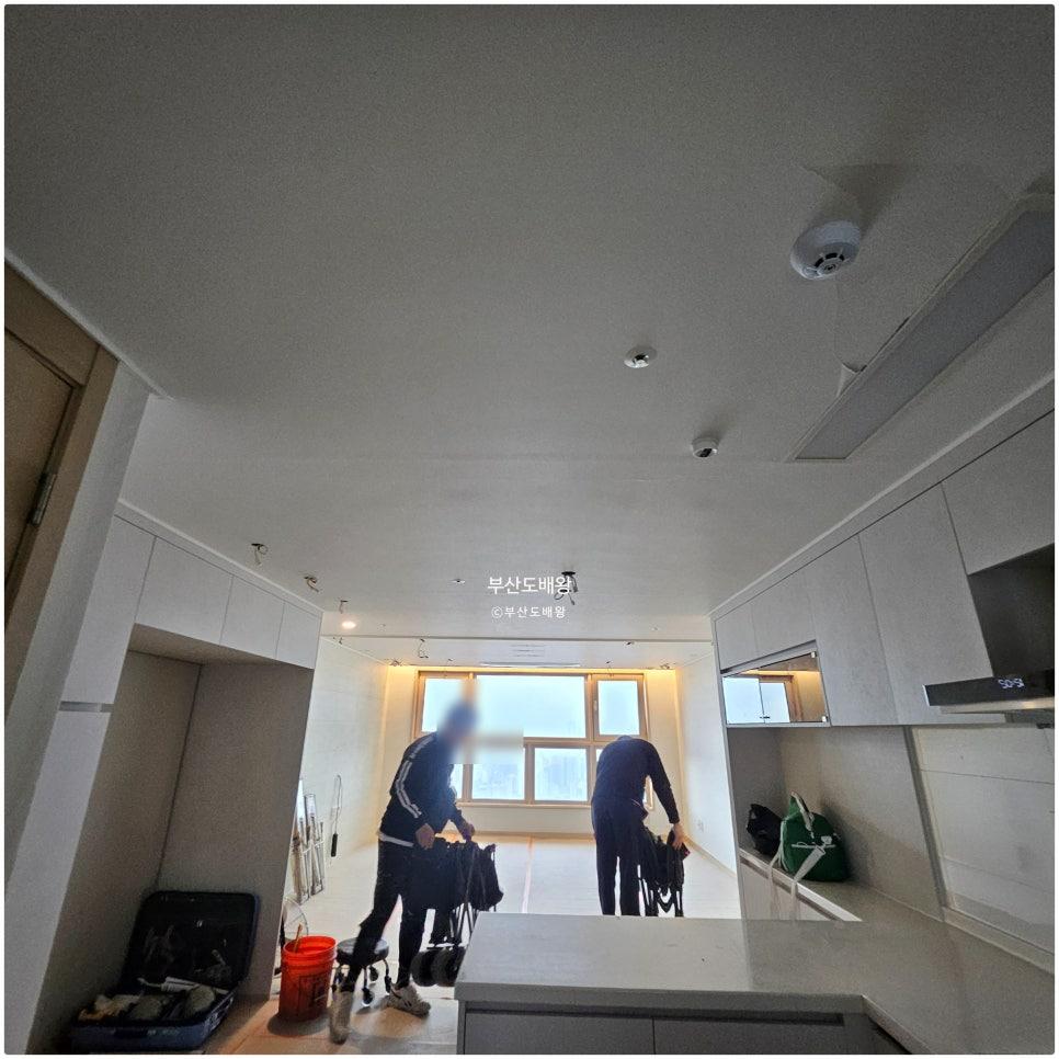 흰색 상판과 캐비닛이 배치된 주방 창가 쪽