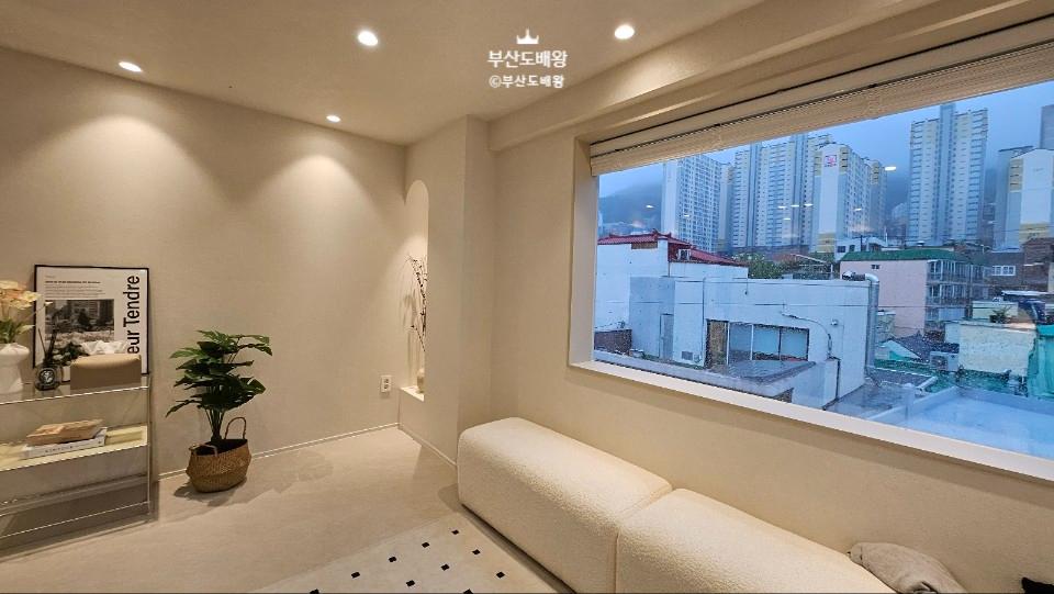도시 풍경이 보이는 창가와 베이지색 소파