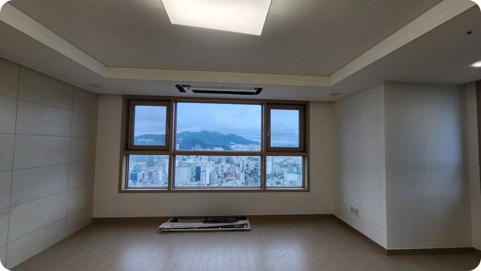 도시 전경이 보이는 큰 창호와 흰색 벽면