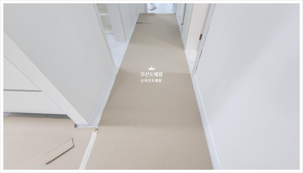 베이지색 바닥재와 흰색 벽면의 복도