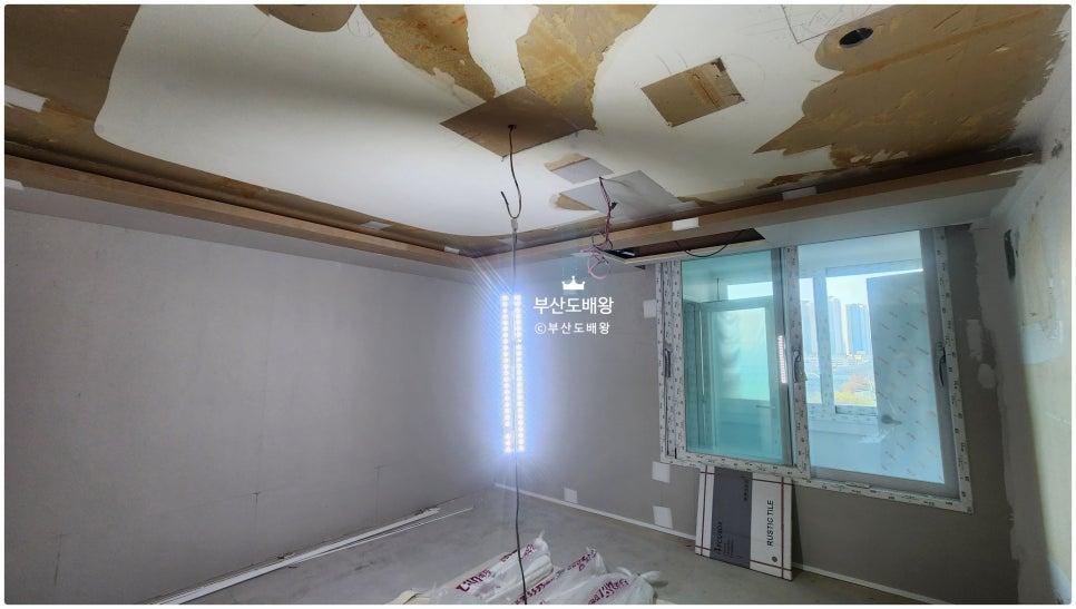 천장 철거 후 흰색 타일 바닥 위로 보이는 유리 패널과 벽면