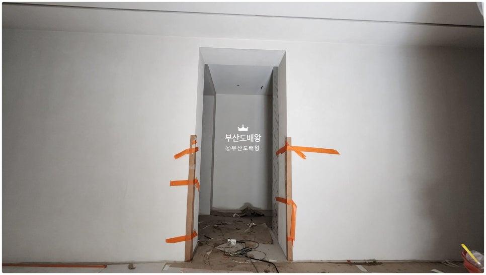 오렌지색 테이프로 보드를 고정한 복도 시공 현장