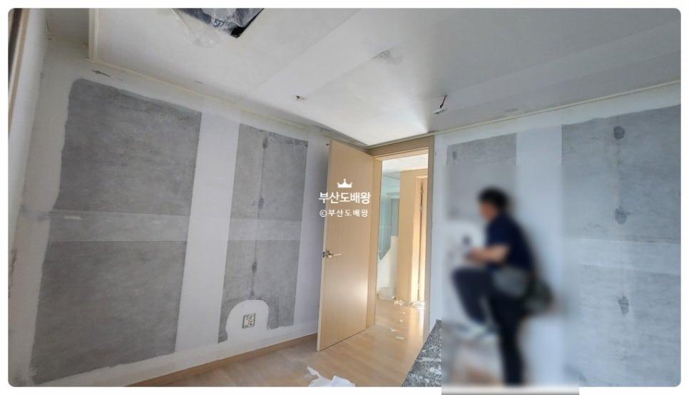 회색 페인트가 부분적으로 칠해진 벽면과 문