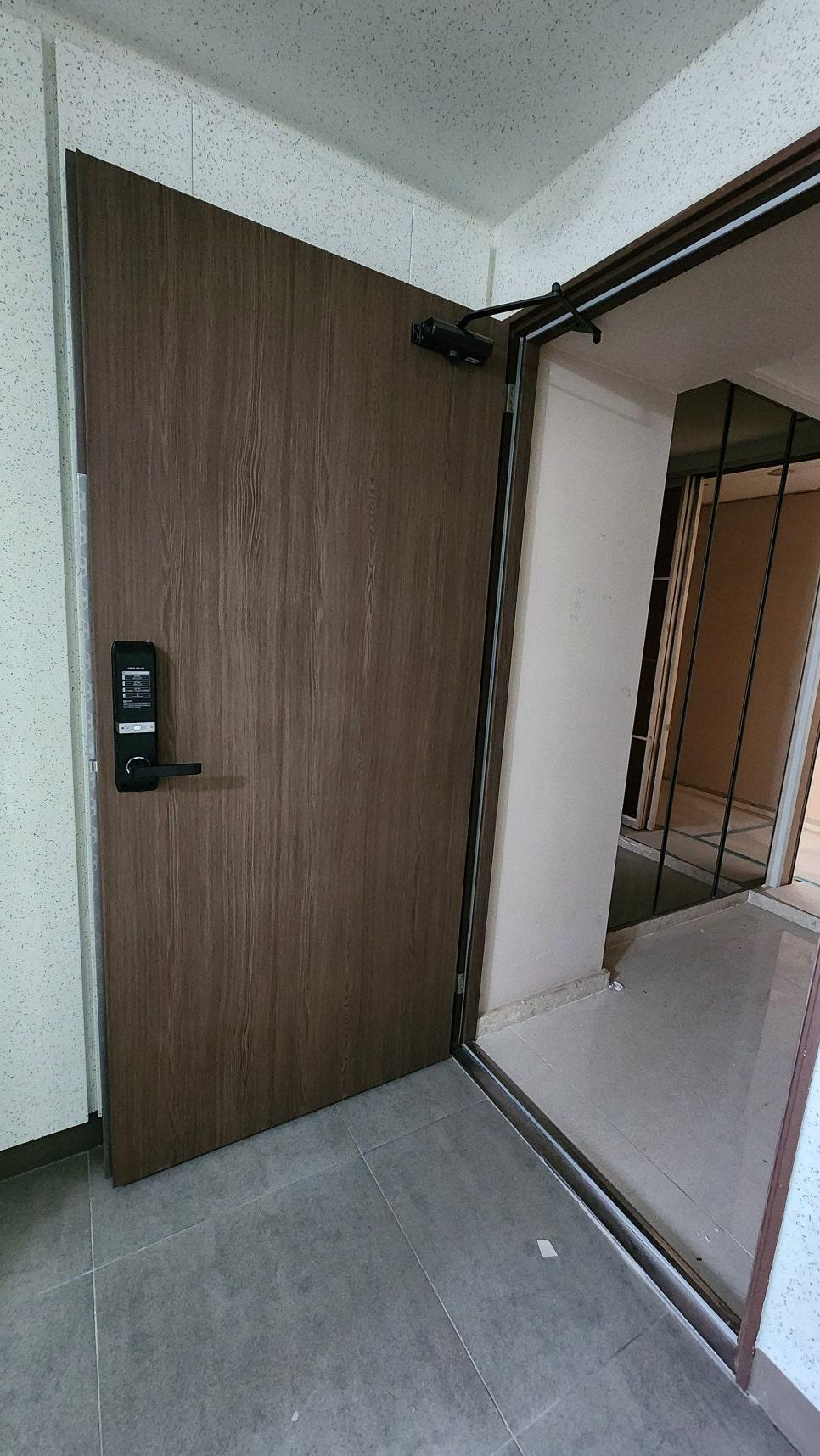 삼성 프리미엄 우드로 마감된 현관 도어와 회색 타일 바닥