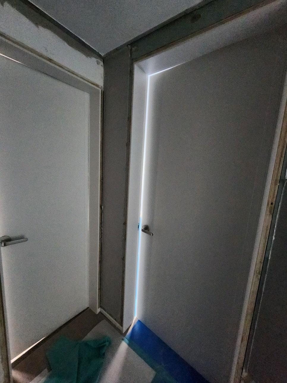 서로 다른 색상의 문과 라인 조명이 있는 복도