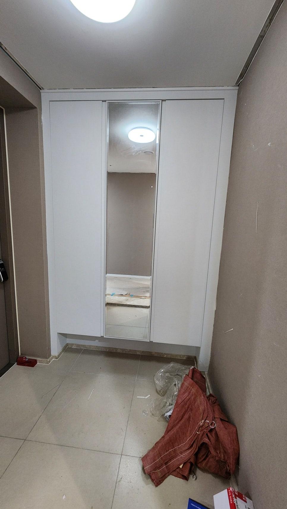 베이지색 벽면과 흰색 슬라이딩 도어가 있는 복도