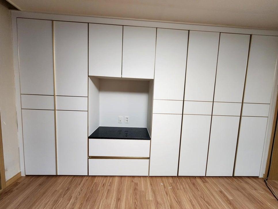 화이트 수납장과 블랙 상판이 대비되는 주방