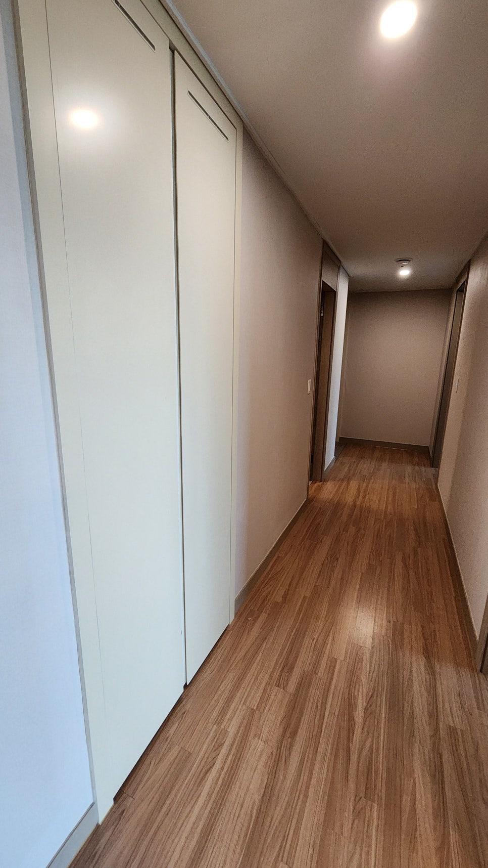 베이지색 도배와 화이트 수납장이 배치된 복도 시공 중