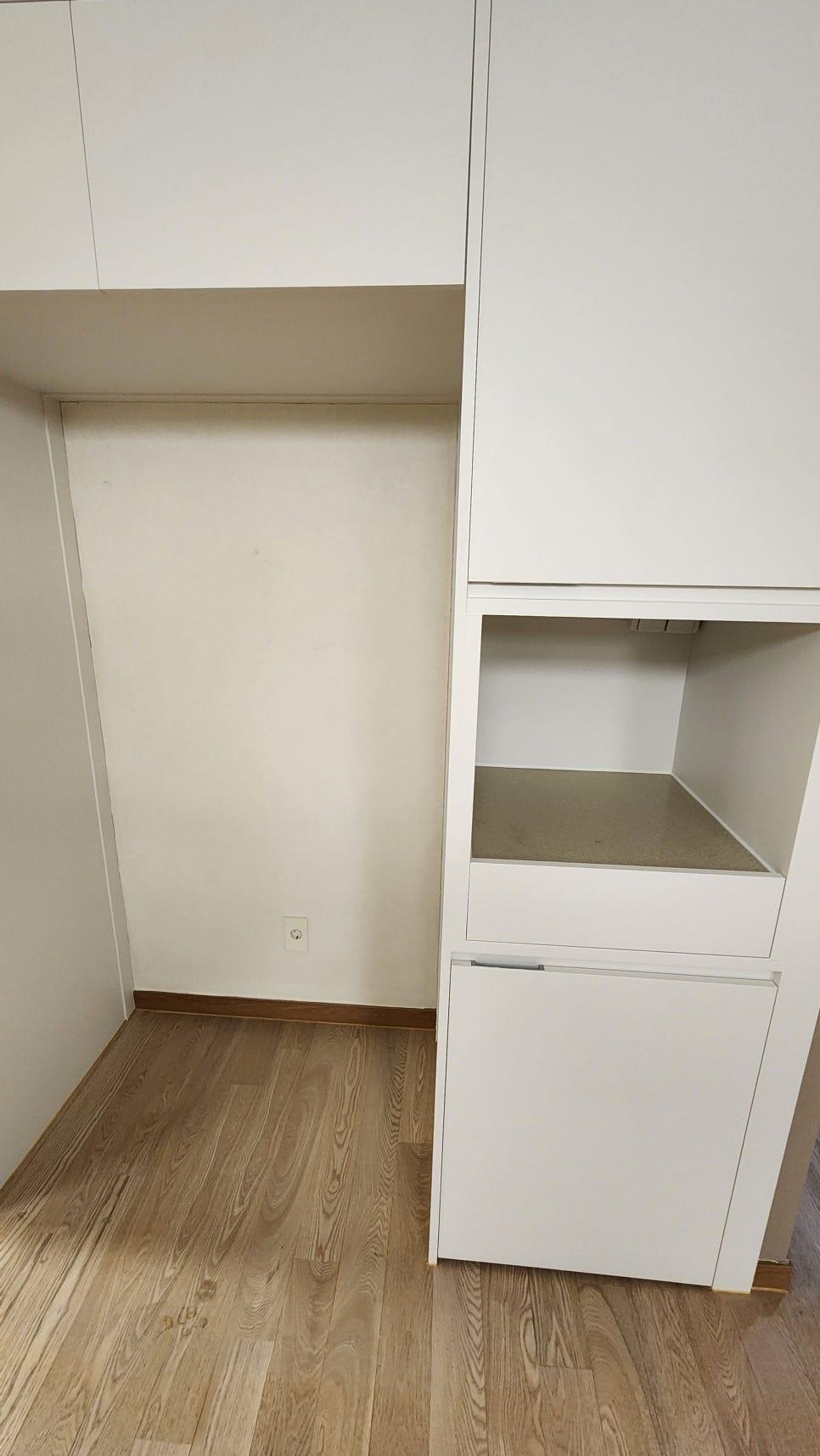 흰색 수납장과 전기 소켓이 있는 벽면