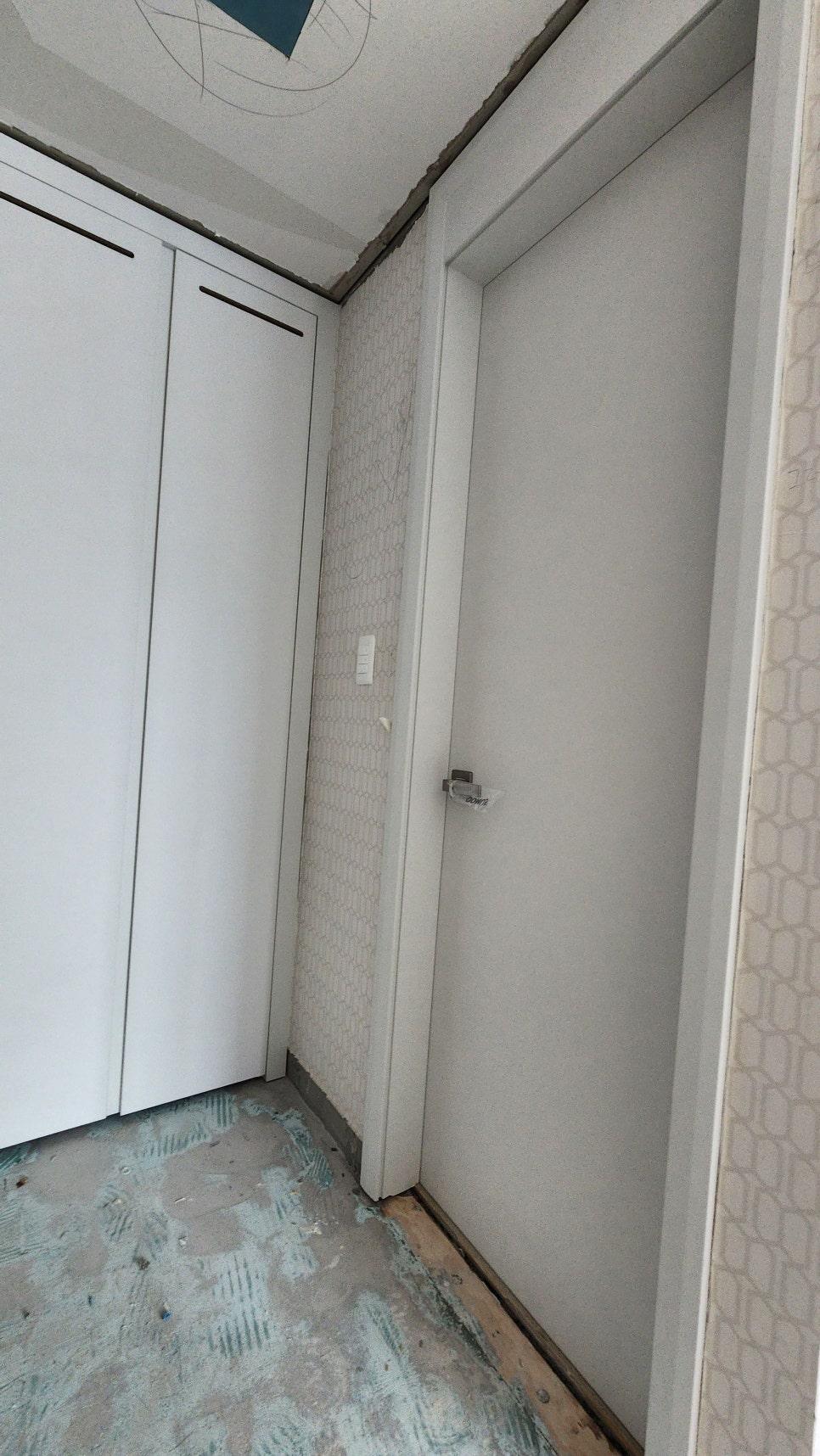 흰색 수납장과 콘크리트 바닥이 보이는 복도