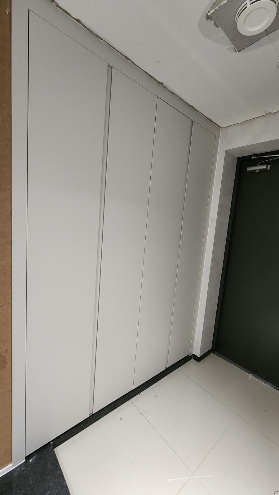 공기 순환기가 설치된 복도의 흰색 수납장과 문