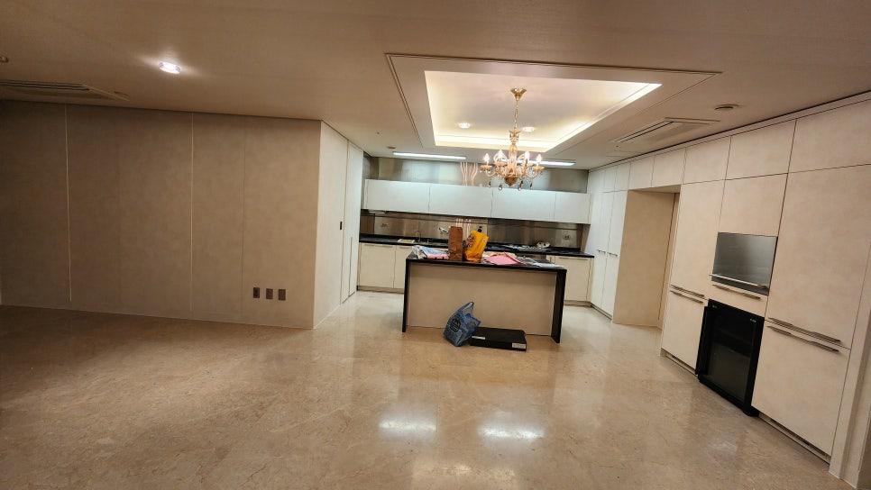 아일랜드와 수납장이 배치된 주방 거실 통합 공간