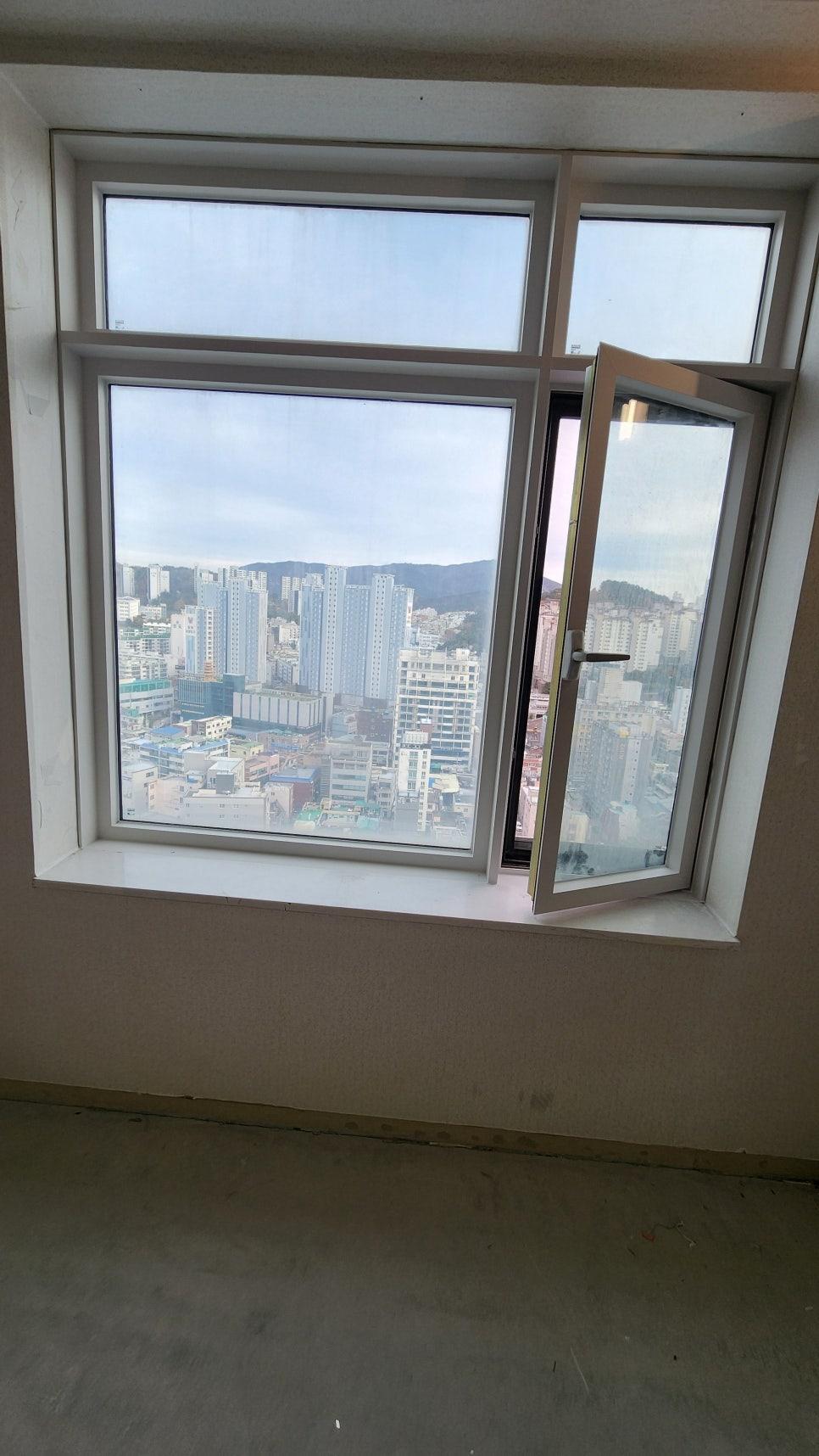 도시 전경이 보이는 열린 창호와 흰색 벽면