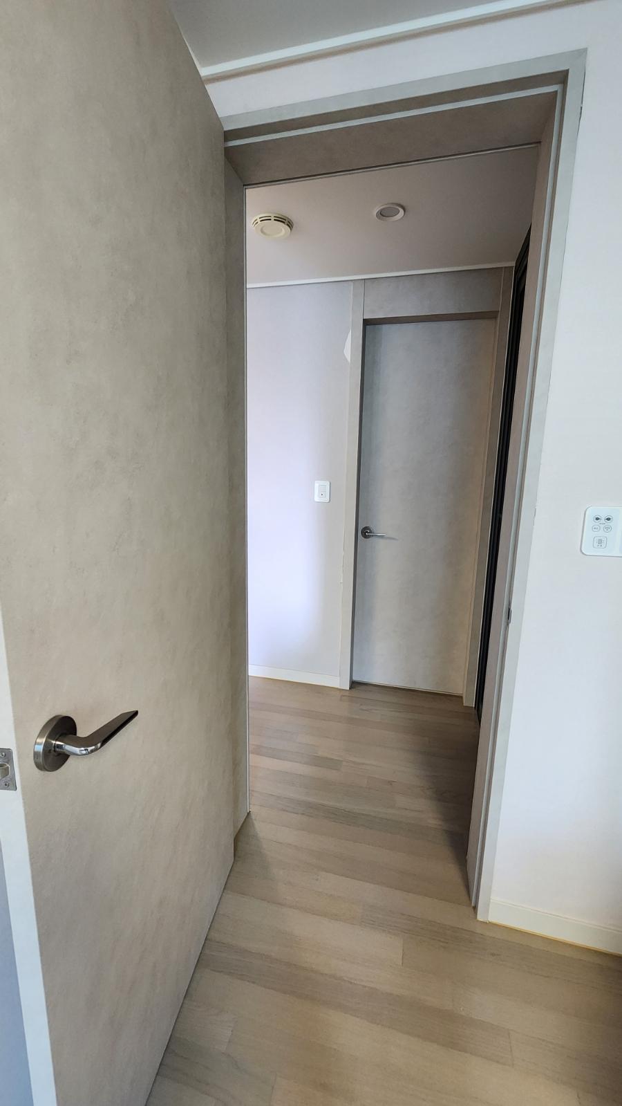 베이지색 벽면과 목재 바닥이 마감된 복도