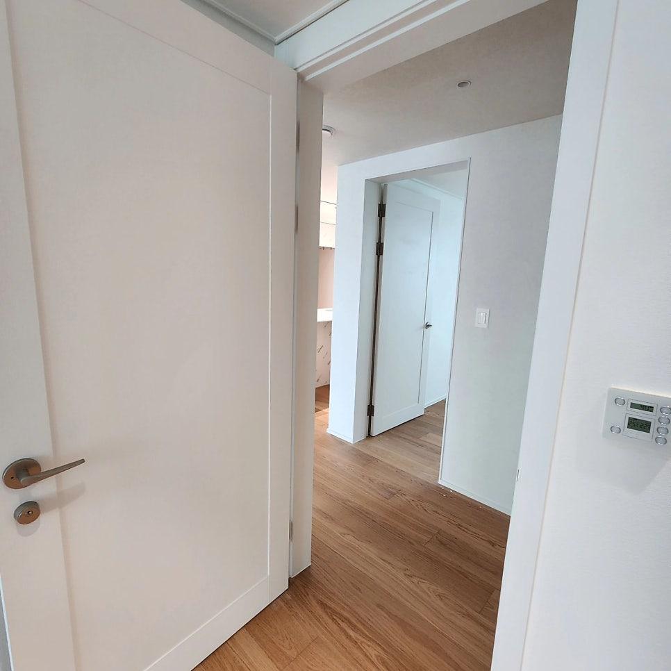 흰색 문과 온도 조절 장치가 설치된 복도 공간