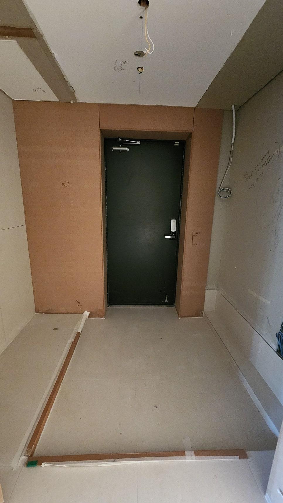 전선이 노출된 천장과 검은색 도어가 보이는 복도