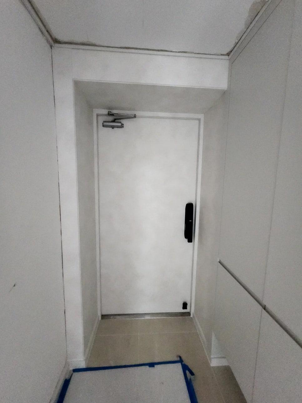 검은색 손잡이가 달린 흰색 도어의 복도