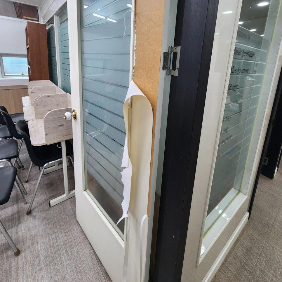 유리 패널 도어와 코르크판이 설치된 벽면