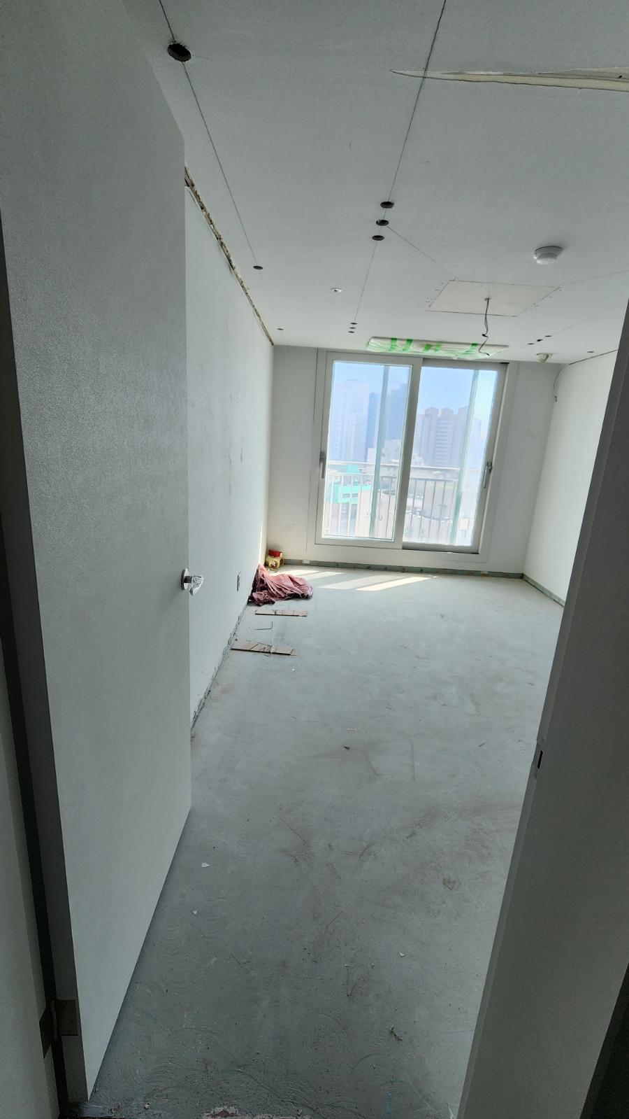 창밖 풍경과 천장 배선이 드러난 텅 빈 공간