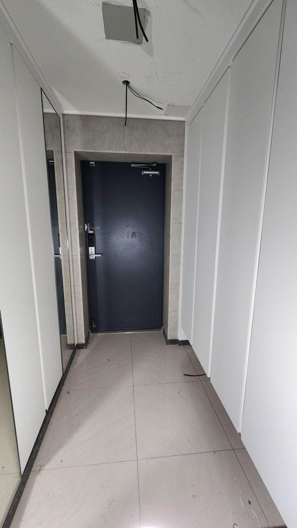 검은색 도어가 설치된 복도와 노출된 천장 전선