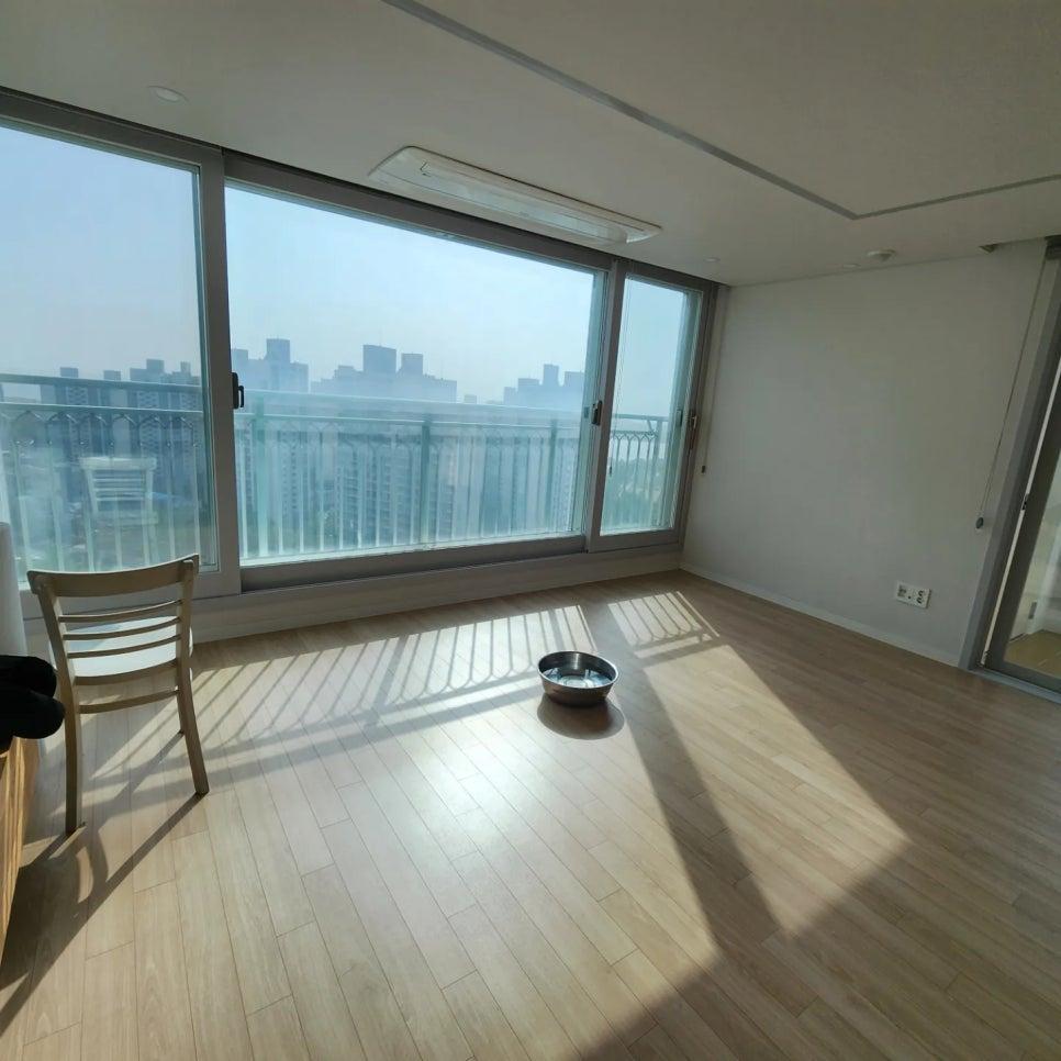 도시 풍경이 보이는 큰 창과 목재 마루가 배치된 모습