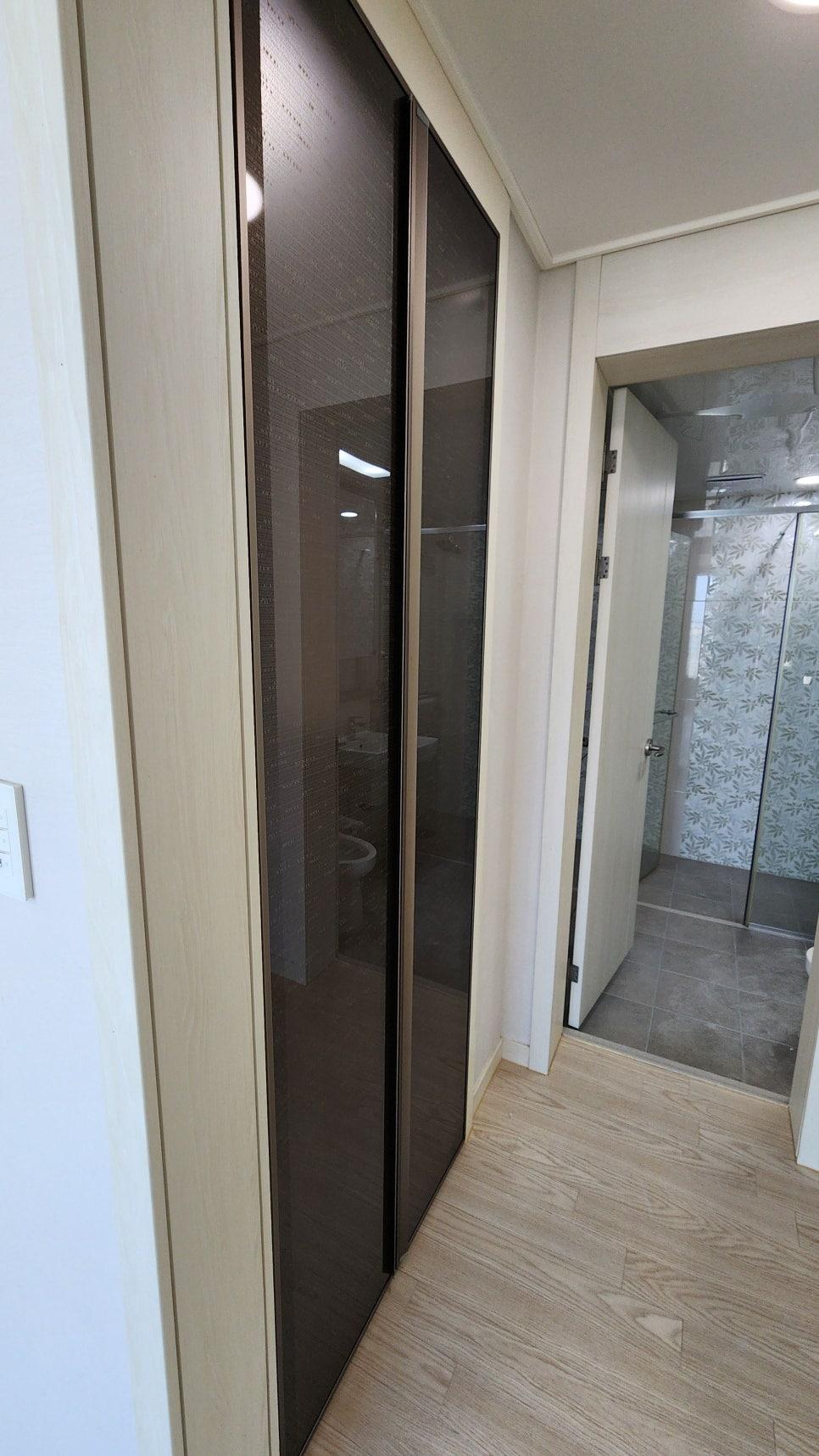 투명 유리 도어 수납장과 샤워 설비가 보이는 실내