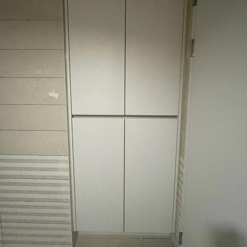 흰색 수납장 문과 줄무늬 벽지가 있는 벽면