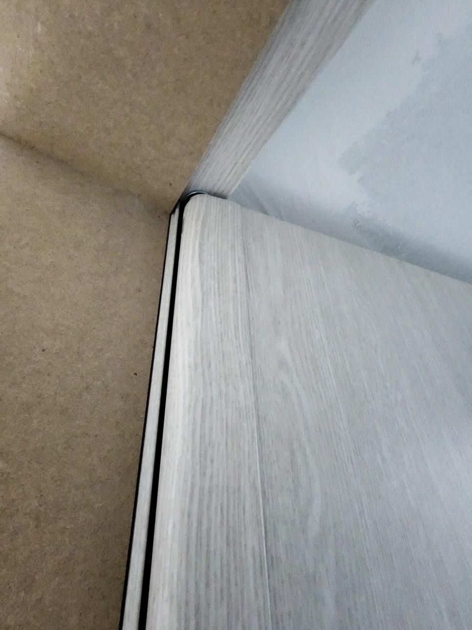 회색 목재 패턴 도어와 벽면 사이의 검은 실선