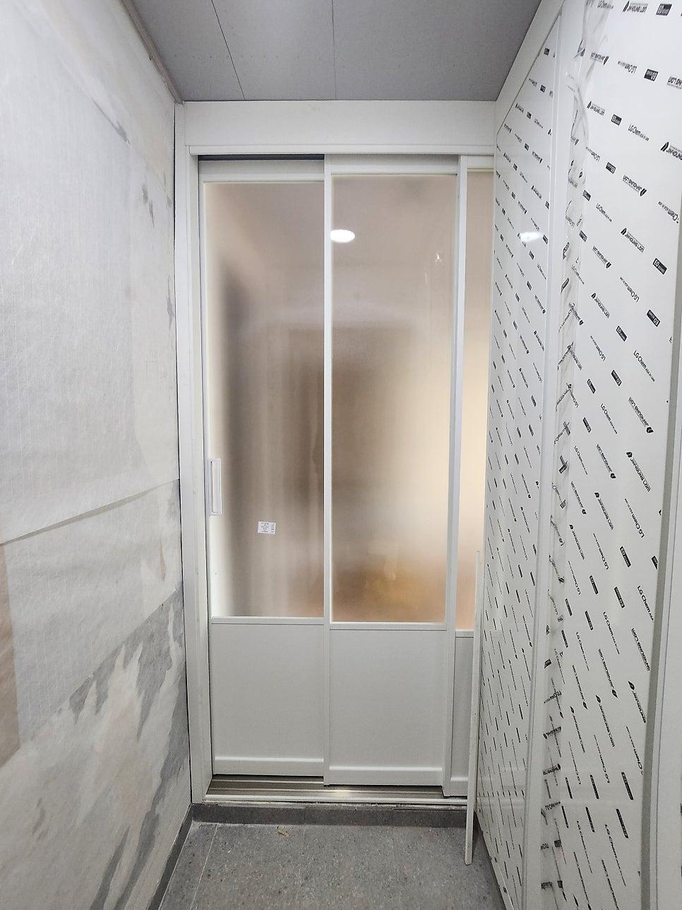 흰색 벽면과 도배지가 마감된 복도의 시공 전 모습
