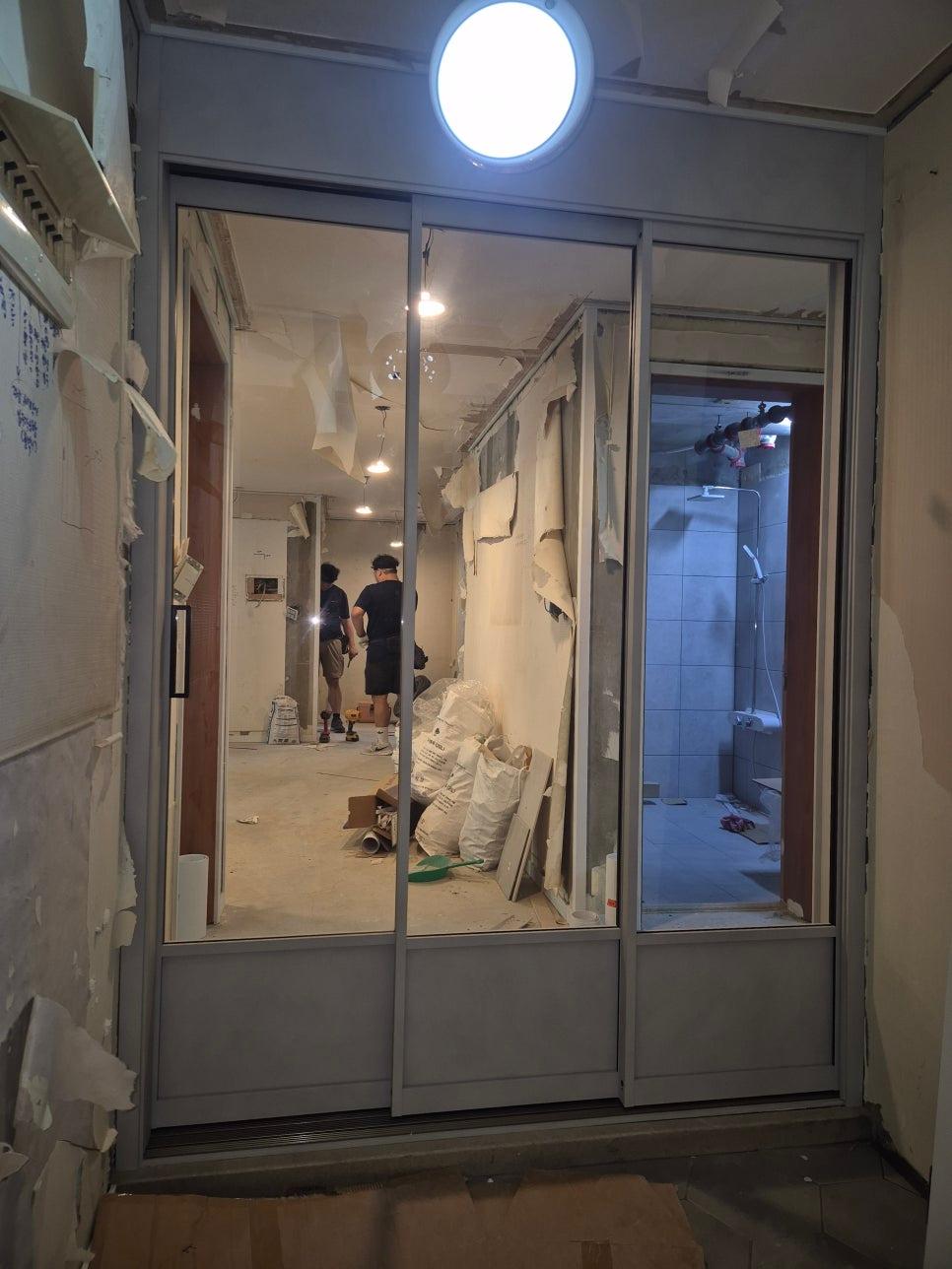 도배지가 부분적으로 제거된 복도 작업 공간