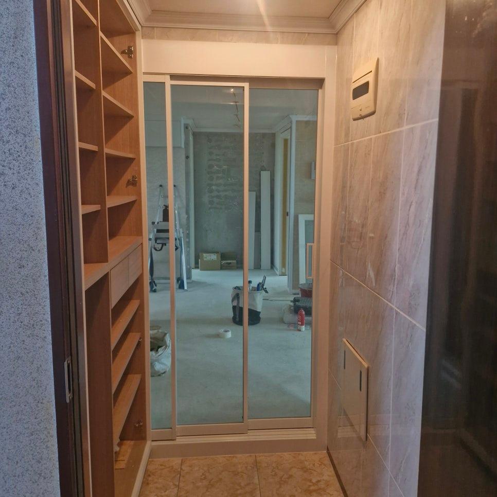 유리 도어와 목재 수납장이 배치된 복도 모습