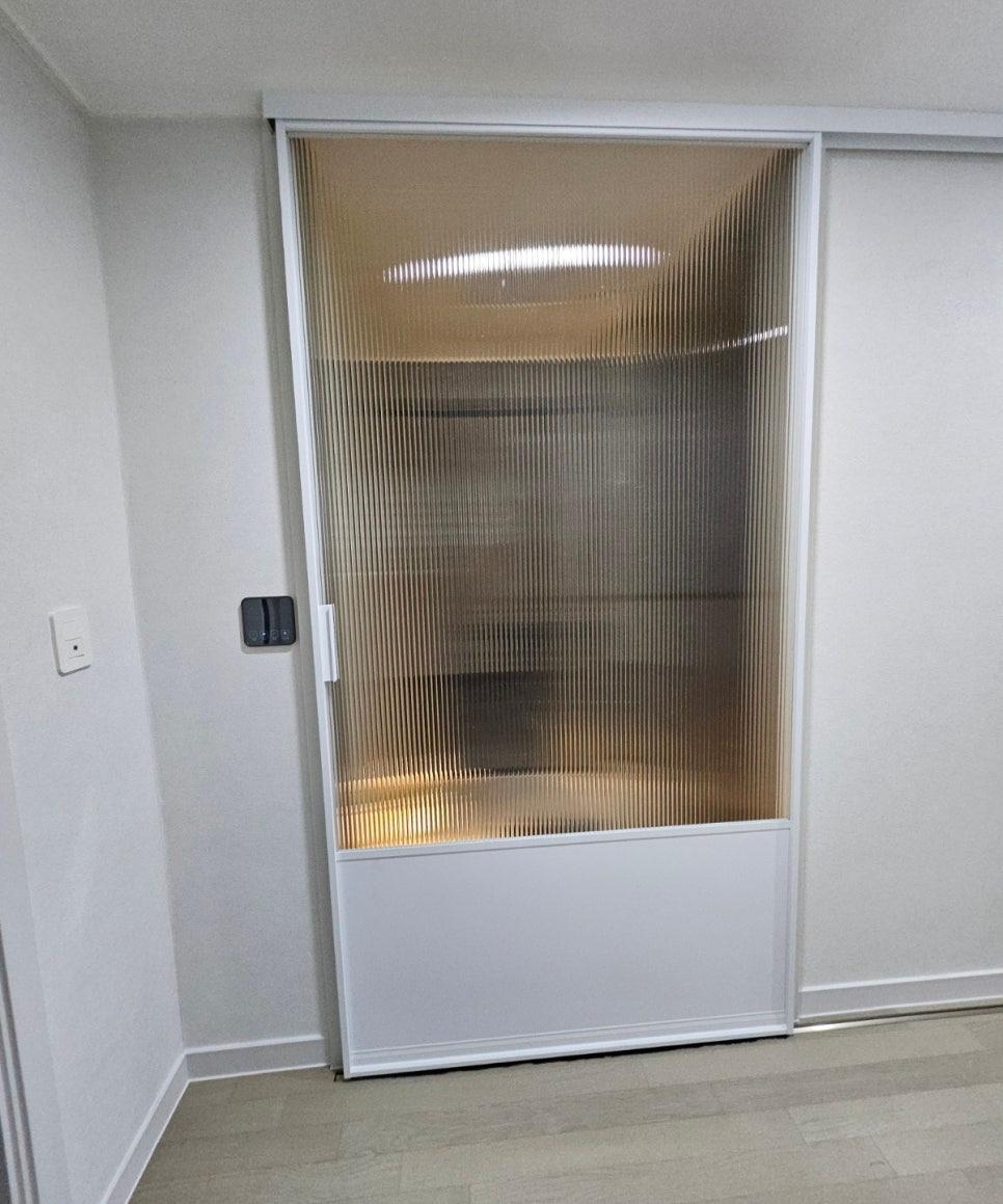 화이트 프레임과 세로 패턴 유리가 완성한 깨끗한 입구