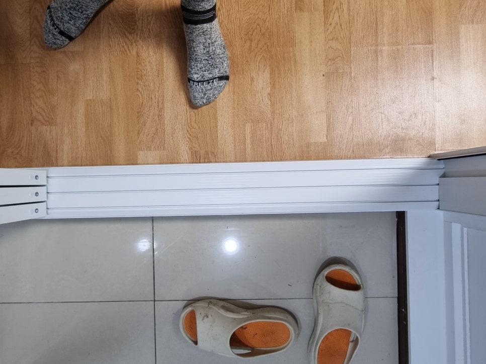 중문 하부 레일과 현관 타일·거실 마루의 경계 마감