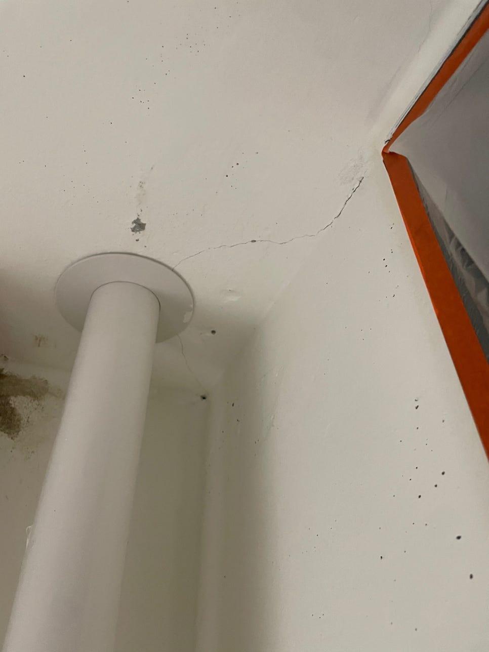 벽면 균열과 오렌지색 테이프가 부착된 천장 근접 모습