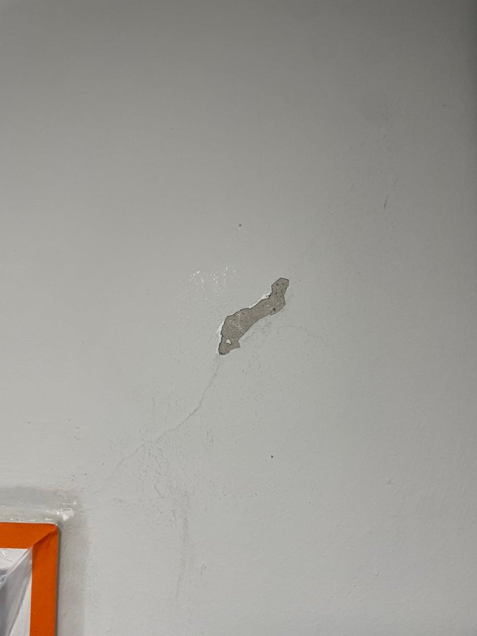 흰색 페인트가 벗겨져 내부 벽체가 노출된 부분