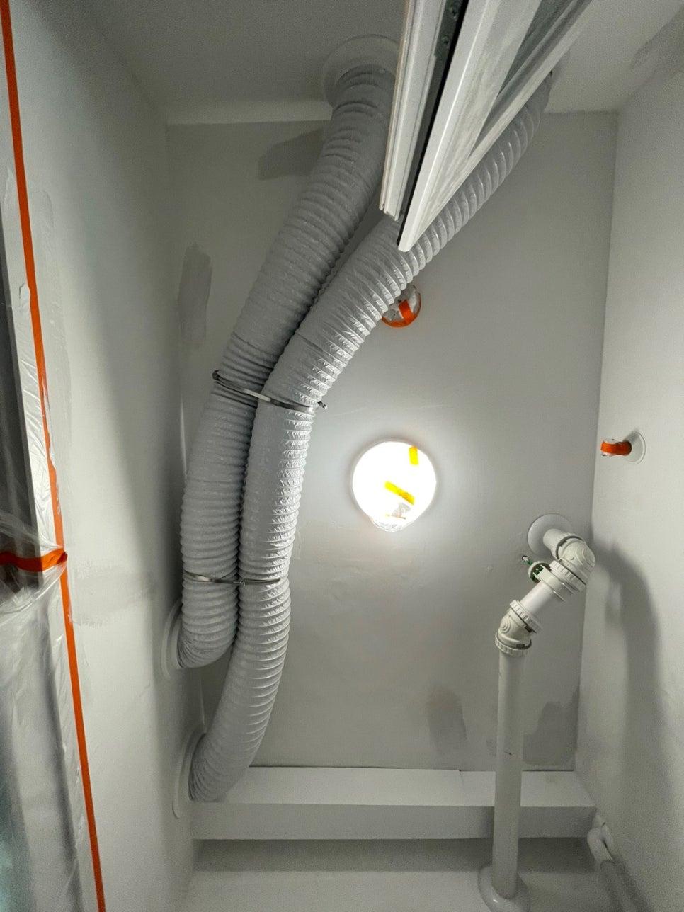 원형 조명과 흰색 PVC 파이프가 보이는 공간