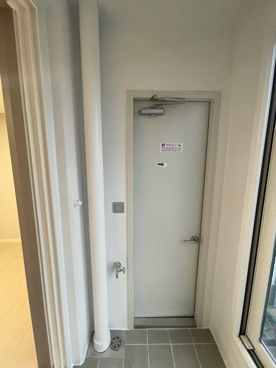 회색 타일 바닥과 화이트 벽면이 어우러진 현관