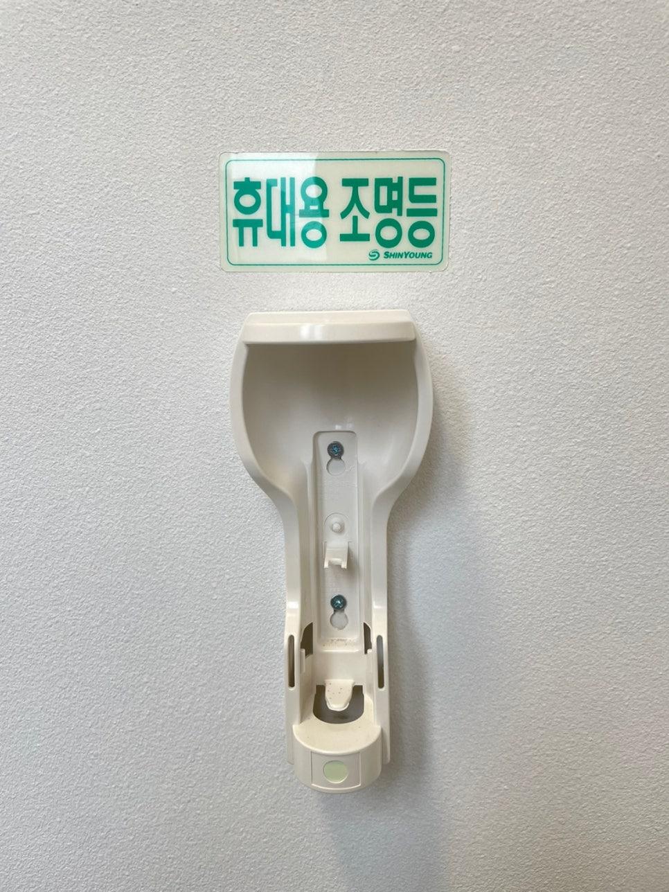 흰색 수전과 녹색 표지판이 설치된 벽면