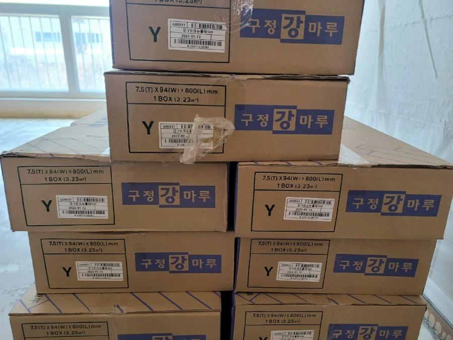 창가 쪽에 적재된 마루 자재 박스들